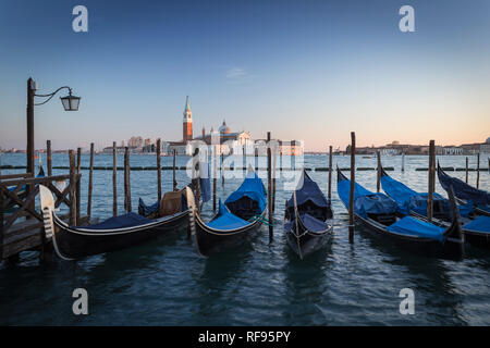 Gondole attraccate di fronte alla chiesa di San Giorgio Maggiore, Venezia, Italia Foto Stock