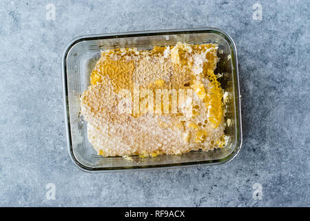 Freschi pezzi di favo di miele in recipiente di vetro. Alimenti biologici. Foto Stock