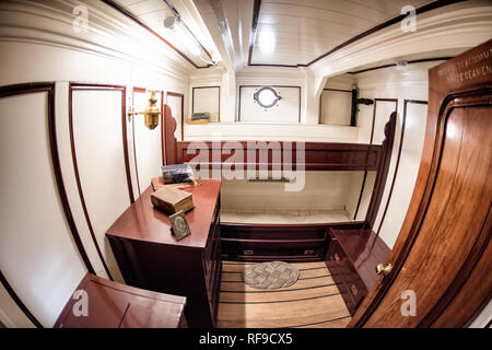 Cutty Sark Officer's Cabin Greenwich Londra // GREENWICH, Londra — la cabina dell'ufficiale a bordo del Cutty Sark, uno degli ultimi tagliafuoco costruiti e l'unico sopravvissuto ancora oggi. Costruita nel 1869, questa nave a vela britannica era una volta tra le navi più veloci della sua epoca, rinomata per il trasporto di tè dalla Cina a Londra in tempi record. Dopo che le navi a vapore ottennero vantaggio con l'apertura del canale di Suez, il Cutty Sark fu riutilizzato per il commercio australiano della lana fino al 1895. Oggi conservata come nave museo e popolare attrazione turistica di Greenwich, la nave offre ai visitatori un'occhiata Foto Stock
