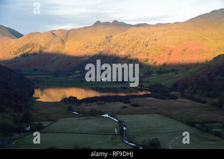 Ombra slitta verso la collina sopra fratelli acqua verso il Wainwright Angletarn Lucci, Dovedale, Parco Nazionale del Distretto dei Laghi, Cumbria, Inghilterra. Foto Stock