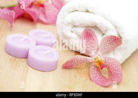 Tealight candele e asciugamano bianco con orchidee Foto Stock