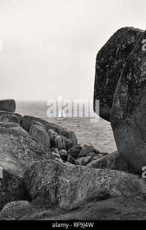 Yacht passando Peninnis Testa, St. Mary's, isole Scilly, UK. Versione in bianco e nero Foto Stock