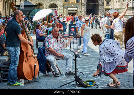 Due musicisti di strada suona il violino e violoncello in strade affollate della città di Firenze, Italia. Foto Stock