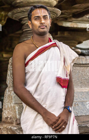 Belavadi, Karnataka, India - 2 Novembre 2013: Closeup di Prashant Bharathwraj, il giovane sacerdote e custode del tempio si presenta come un uomo serio wra Foto Stock