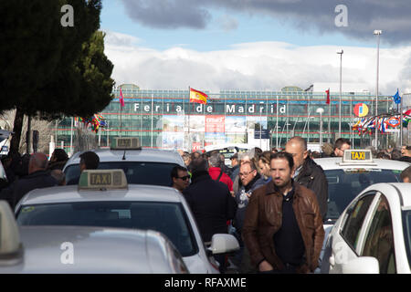 Madrid, Spagna. 24 gen 2019. I tassisti sono veduto camminare in mezzo taxi parcheggiato sulla strada durante lo sciopero.Migliaia di conducenti di taxi sono ancora in sciopero vicino a Fitur, il Salone del Turismo che si terrà questa settimana presso il centro fieristico Ifema di Madrid a richiesta per più stringente regolazione per noleggio veicoli con conducente (VTC), che utilizzano Uber Cabify o applicazioni. Credito: Lito Lizana/SOPA Immagini/ZUMA filo/Alamy Live News Foto Stock