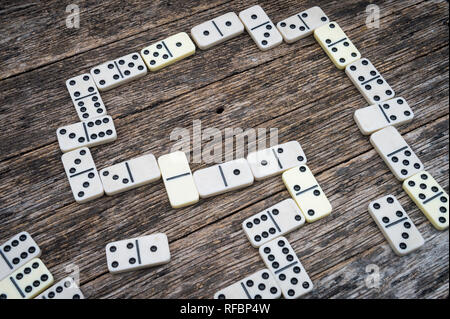 Classico gioco di domino di cubani in corso su un vecchio stile in legno stagionato tabella all'aperto Foto Stock