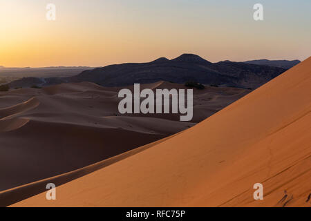 Il riscaldamento globale del concetto. Lonely dune di sabbia sotto drammatico tramonto Cielo a siccità il paesaggio del deserto. Africa Foto Stock