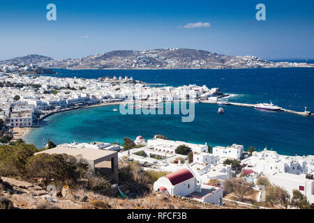 Vista panoramica della città di Mykonos harbour con famosi mulini a vento dalle colline sopra su una soleggiata giornata estiva, Mykonos, Cicladi Grecia Foto Stock