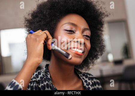 Bella americano africano donna con capelli ricci cercando felice Foto Stock