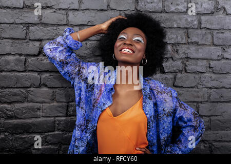 Dai capelli scuri modello bellissimo con grandi orecchini luminosamente sorridente Foto Stock