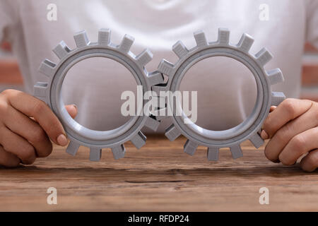 Close-up di commercianti di mano grigio di giunzione delle marce sulla scrivania in legno al posto di lavoro Foto Stock