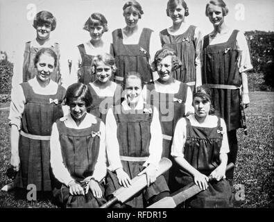 Inizio del ventesimo secolo fotografia in bianco e nero che mostra una delle ragazze di Cricket. Gli undici membri del team sono mostrati in posa per la telecamera e due ragazze in prima fila sono entrambi azienda mazze da cricket. Essi sono tutti indossano la stessa uniforme. Foto Stock