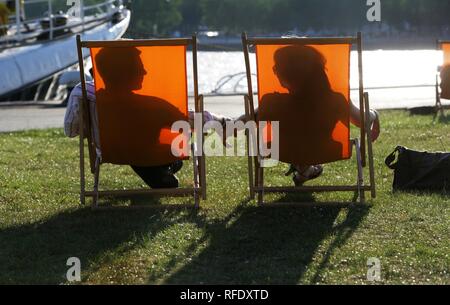 Giovane uomo, donna, seduto in una sedia a sdraio Foto Stock