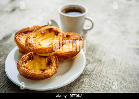 Il Portogallo crostate di uovo Pastel de Nata che serve sulla piastra con caffè Foto Stock