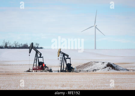 L'olio rimane re in Alberta ma più e più energia eolica turbine sono che ne adornano il paesaggio, come si vede qui in inverno in Alberta, Canada. Foto Stock