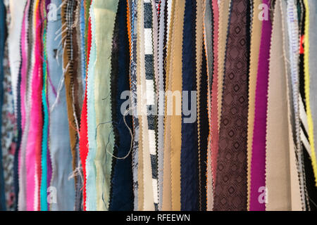 Tessuti e prodotti tessili di campioni in un negozio della fabbrica o del negozio. Colori e motivi diversi sul mercato. Tessuti industriali. Foto Stock