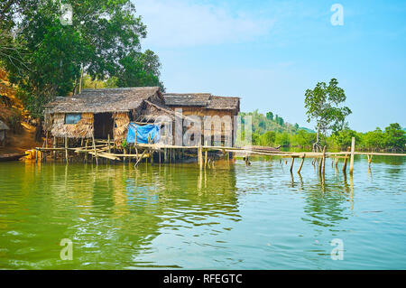 La meschina stilt capanne di palme Nipa e legno sulla riva del fiume Kangy, Chuang Tha zona, Myanmar. Foto Stock