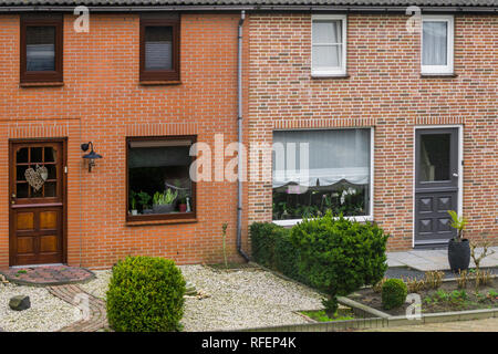 Olandese moderna casa a schiera esterno con giardini, piante dietro le finestre, case in un villaggio olandese Foto Stock