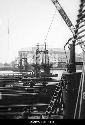 Lo smantellamento dell'originale Lambeth Bridge, oltre il Fiume Tamigi, a Londra, Inghilterra.Questo era moderno ponte è stato un ponte di sospensione, 828 piedi (252.4 m) long, progettato da Peter W. Barlow. Sancito da un atto del Parlamento nel 1860, e aperto come un ponte a pedaggio su 10 Novembre 1862. Dubbi circa la sua sicurezza, accoppiato con la sua goffamente ripida scoraggiando gli approcci a cavallo il traffico, intende esso divenne presto utilizzato quasi esclusivamente come un attraversamento pedonale. Essa ha cessato di essere un ponte a pedaggio nel 1879, esso è stato da allora gravemente corrosi, e fu chiusa nel 1910. Foto Stock