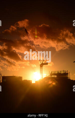 Gru sul sito di costruzione al tramonto su Leeds City skyline Yorkshire Regno Unito Foto Stock