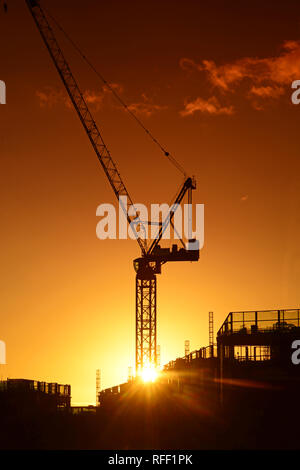 Gru sul sito di costruzione al tramonto su Leeds City skyline Yorkshire Regno Unito Foto Stock