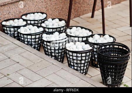 Palline da golf in cesti sulla pavimentazione. Foto Stock