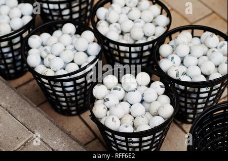 Palline da golf in cesti sulla pavimentazione. Foto Stock