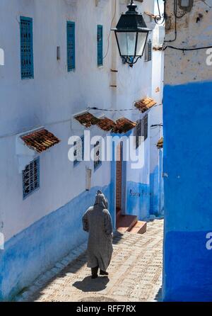 Locale in Djellaba, scale attraverso una stretta viuzza, case blu, Medina di Chefchaouen, Chaouen, Tanger-Tétouan, Marocco Foto Stock