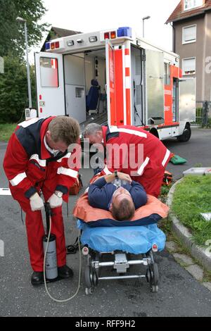 DEU Germania : Rescue paramedici pronto soccorso dopo un incidente con un uomo ferito ad una gamba. ambulanza servizio antincendio. Corsi di formazione Foto Stock