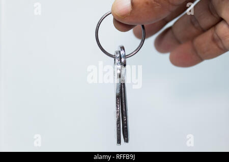 Maschio a mano portachiavi di contenimento isolato su sfondo bianco con Copia area di spazio. Chiave auto e chiave di blocco isolato su sfondo bianco con portachiavi. Foto Stock