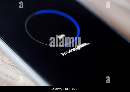Installazione aggiornamento sullo smartphone sulla tabella closeup, in corso Foto Stock