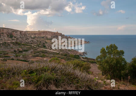 Drammatico paesaggio costiero sulla Eastern Gozo, Malta. Vista su Dahlet Qorrot Bay e San Filippo Bay e Sopu Tower in distanza. Foto Stock