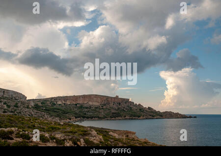 Drammatico paesaggio costiero sulla Eastern Gozo, Malta. Vista su Dahlet Qorrot Bay e San Filippo Bay e Sopu Tower in distanza. Foto Stock