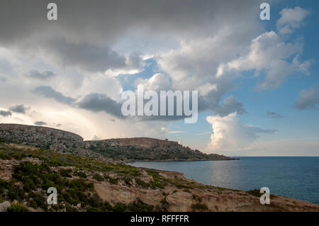 Drammatico paesaggio costiero sulla Eastern Gozo, Malta. Vista su Dahlet Qorrot Bay e San Filippo Bay e Sopu Tower in distanza. Foto Stock