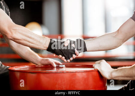 Close-up di una stretta di mano di due uomini prima di lotta al pugilato ring in palestra Foto Stock