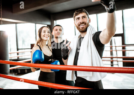 Amici facendo selfie ritratto, divertirsi insieme durante la pausa di sport dopo il corso di formazione sull'anello di boxe in palestra Foto Stock