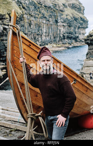 Un isolano Faerøer indossando un tradizionale delle isole Faeroeer maglione di lana e il cappello in Gjogv Esturoy nelle isole Faerøer. Foto Stock