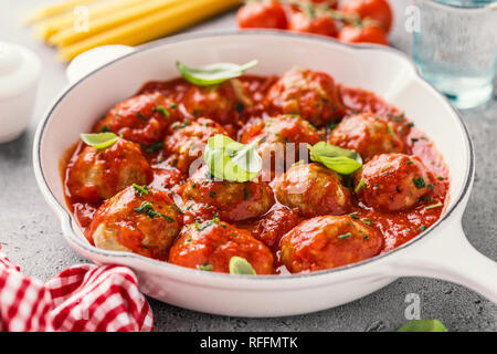 In casa le polpette di carne con salsa di pomodoro e spezie, servito in padella bianco su sfondo grigio. Primo piano. Foto Stock