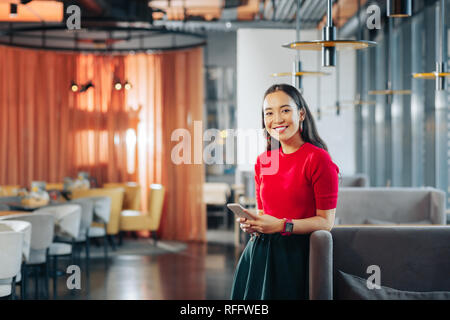 Allegro dark-eyed woman standing nel grande ristorante Foto Stock