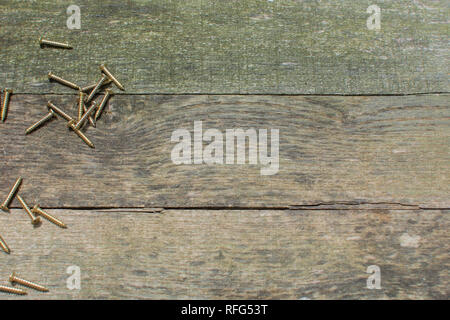 Weathered pallet di pannelli di legno come uno sfondo con ottone legno viti poste sul lato sinistro. Foto Stock