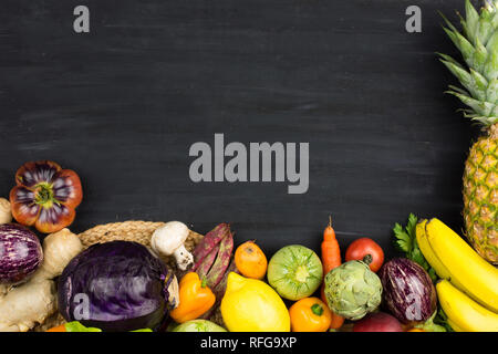Telaio di verdure fresche e la frutta in gesso nero lo sfondo. Copia dello spazio. Angolo di Alta Vista. Foto Stock