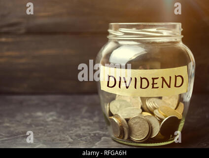 Vaso di vetro con la parola dividendo. Un dividendo è un pagamento effettuato da una società ai suoi soci come una distribuzione di utili. Concetto di pinna di business Foto Stock