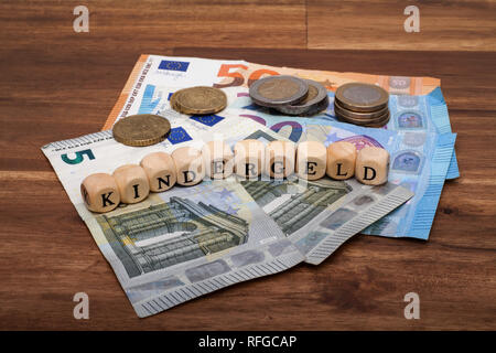 Die Euro Geldscheine und Münzen liegen auf dem Tisch mit dem Wort Kindergeld Foto Stock