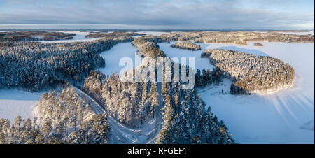 Antenna ad angolo ampio paesaggio invernale panorama della panoramica cresta strada forestale in Punkaharju, Finlandia. Foto Stock