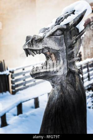 Scultura in legno raffigurante un drago, bocca spalancata, coperto di neve Foto Stock