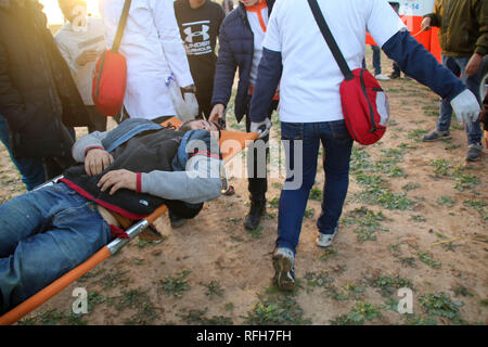 La striscia di Gaza, la Palestina. 25 gennaio, 2019. I medici hanno visto che trasporta un manifestante ferito durante gli scontri.i cittadini palestinesi e il sionista forze di occupazione si scontrarono a nord della Striscia di Gaza nella zona di Abu Safiya in segno di protesta contro il riconoscimento del Presidente americano Trump Gerusalemme come capitale di Israele e ha rifiutato la richiesta di blocco. Credito: Ahmad Hasaballah SOPA/images/ZUMA filo/Alamy Live News Foto Stock