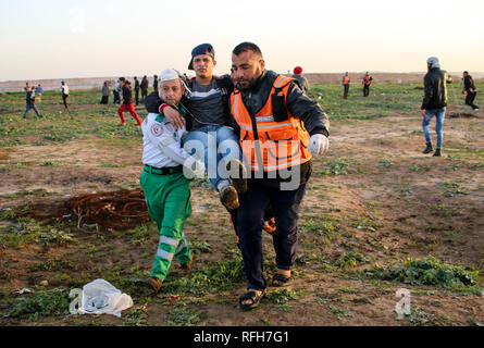 La striscia di Gaza, la Palestina. 25 gennaio, 2019. I medici hanno visto che trasporta un manifestante ferito durante gli scontri.i cittadini palestinesi e il sionista forze di occupazione si scontrarono a nord della Striscia di Gaza nella zona di Abu Safiya in segno di protesta contro il riconoscimento del Presidente americano Trump Gerusalemme come capitale di Israele e ha rifiutato la richiesta di blocco. Credito: Ahmad Hasaballah SOPA/images/ZUMA filo/Alamy Live News Foto Stock