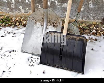 Nero Pala da neve con una pala di argento sulla massa di neve Foto Stock