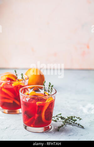 Cocktail alcolici con fette di sangue siciliano arance o campari, rosso fresco succo di arancio su grigio chiaro sfondo concreto, copia spice, profondità di Foto Stock