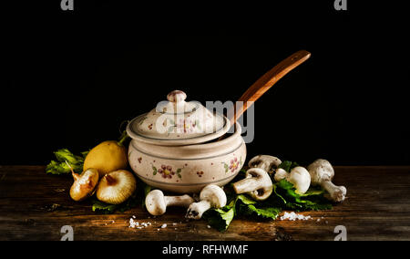 Zuppa di funghi con le cipolle nella zuppiera con ingredienti intorno - primo piano Foto Stock